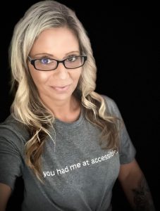 Head shot of Dawn Campbell, white female, blond hair, black rim glasses, wearing a grey t-shirt.