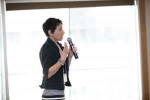 Kelly Johnson holding a microphone while giving a talk at the 24th Annual CASE Conference in Montreal 2019