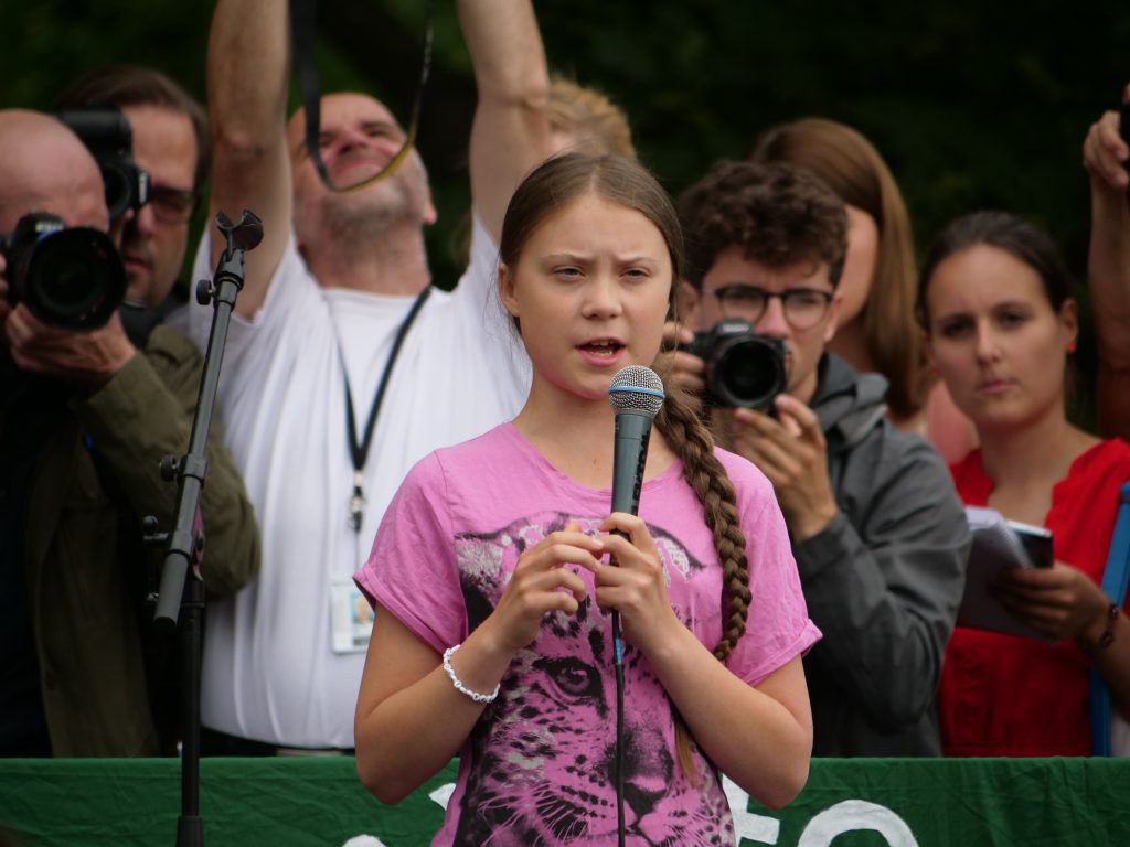Greta Thunberg holding mic at public event